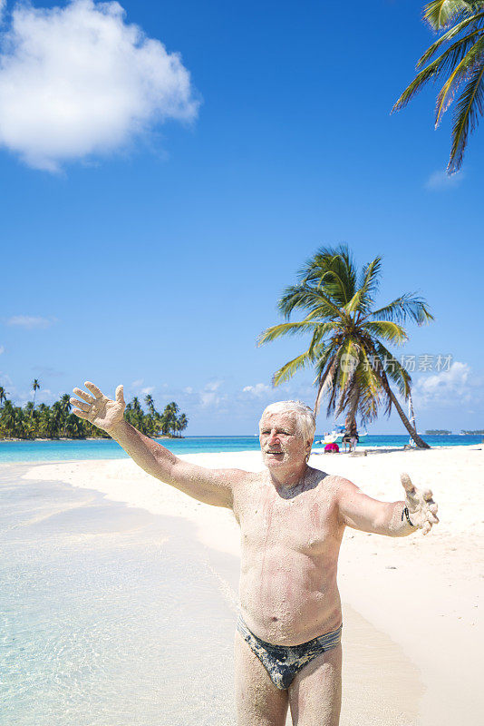 在加勒比海圣布拉斯群岛的海滩上，一位老人张开双手