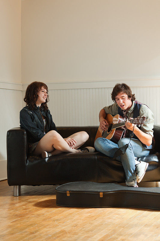 年轻夫妇一起欣赏音乐和弹吉他