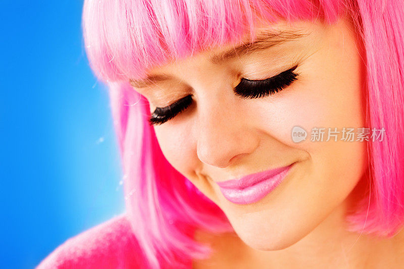 戴着粉色假发和假睫毛的漂亮少女的微笑