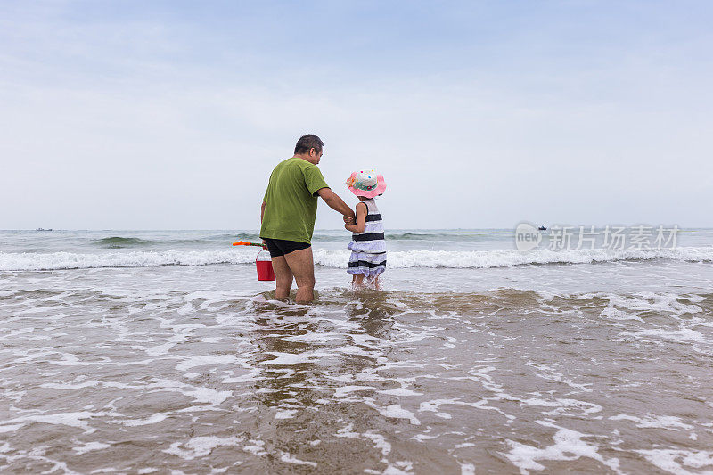 父亲和女儿在海边玩
