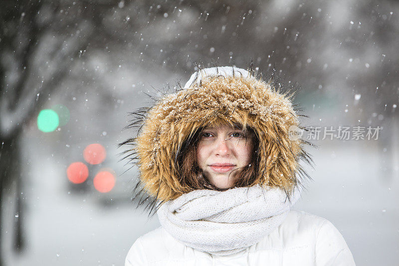 雪下穿着白色夹克的漂亮少女