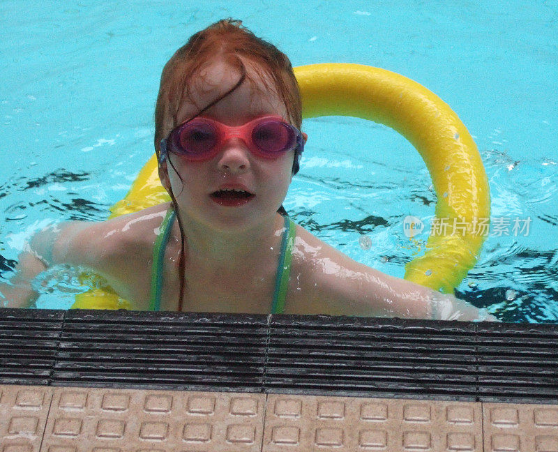 一个小女孩在游泳池里的画面