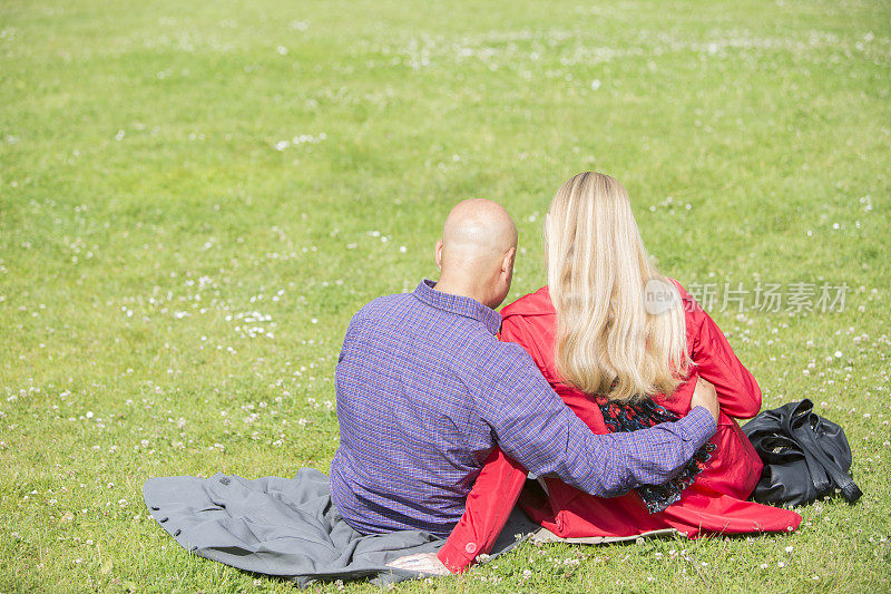 一对情侣坐在草地上拥抱