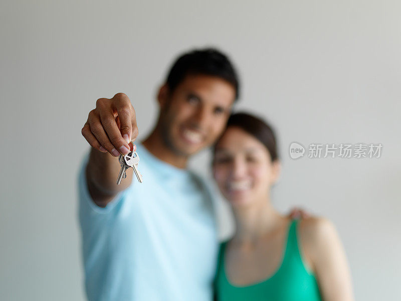 年轻夫妇拿着他们家的钥匙