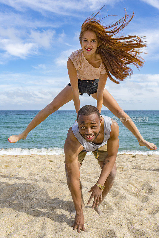 一对情侣在沙滩上玩跳蛙游戏