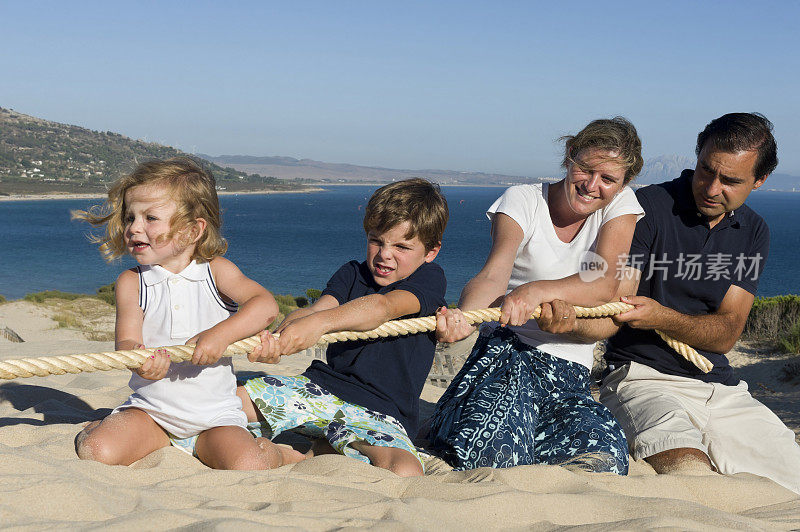 一家人在沙滩上玩拔河