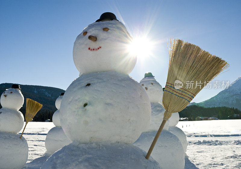 雪人军队-雪人戴着帽子和扫帚在太阳