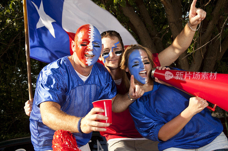 一群兴奋的足球迷在车尾野餐会上大喊大叫。德克萨斯州。