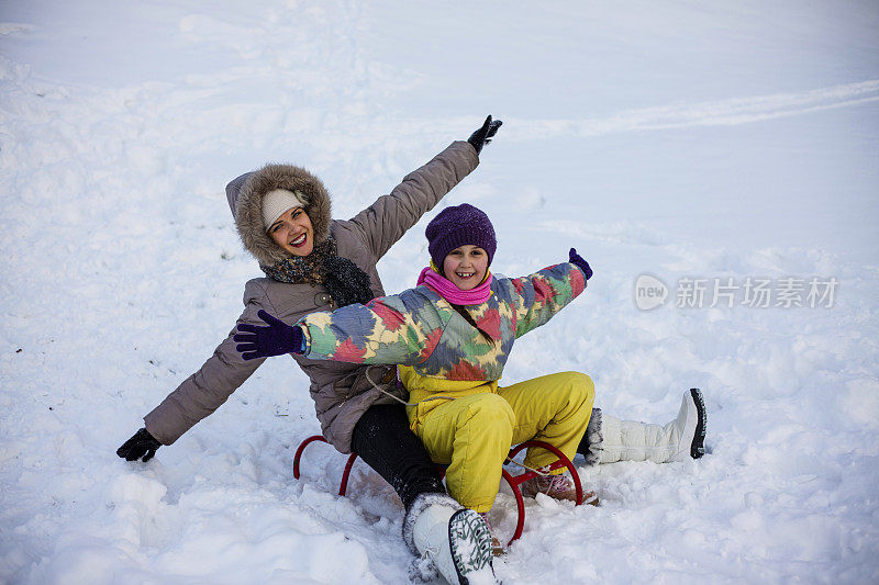 母亲和女儿喜欢坐雪橇