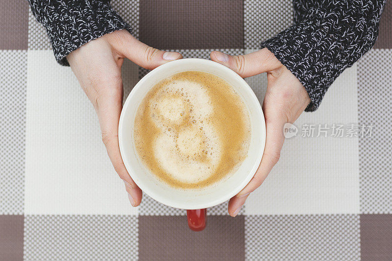 女人手里拿着咖啡杯