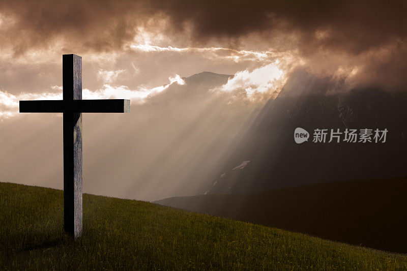耶稣基督的十字架。基督教的木十字架，天空，戏剧性的光，山