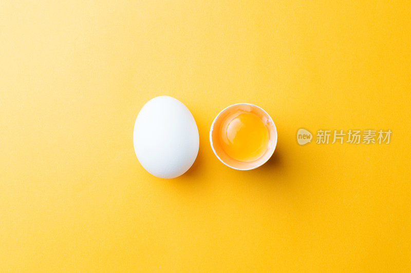 白色的鸡蛋和蛋黄在黄色的背景。赢富数据