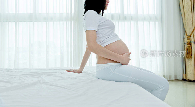 一个孕妇坐在床边