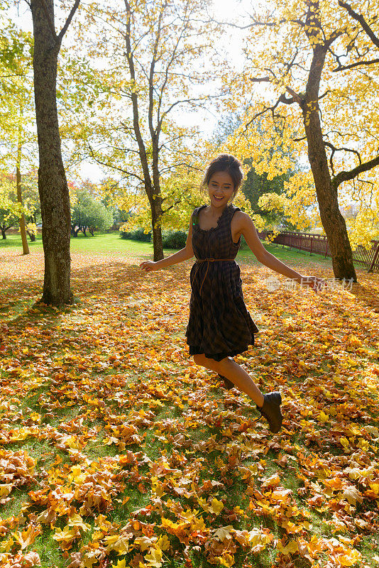 年轻美丽的亚洲女人享受秋天的季节