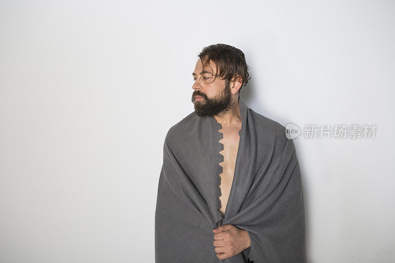 在土耳其伊斯坦布尔的工作室里，一名留着胡子和毛毯的年轻欧洲男性摆姿势