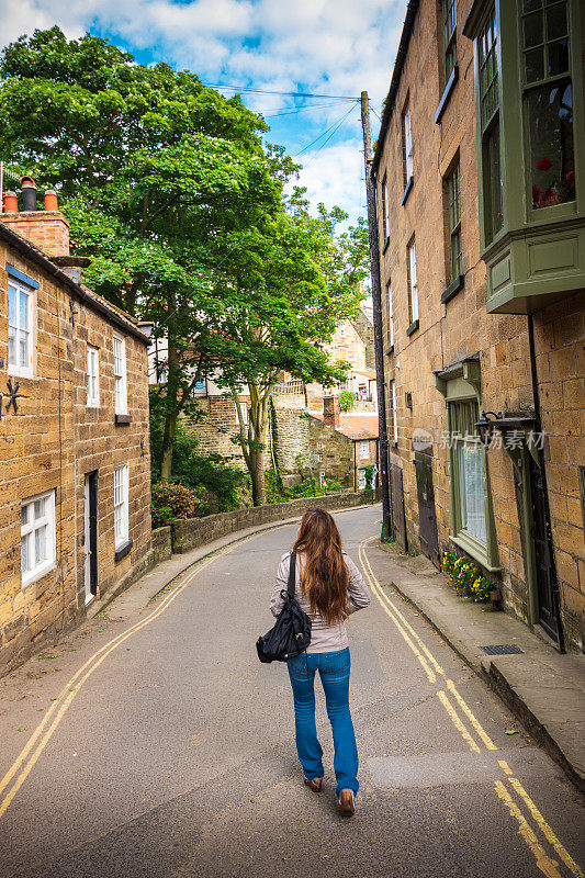 女游客探索迷人的罗宾汉湾狭窄的街道，英国