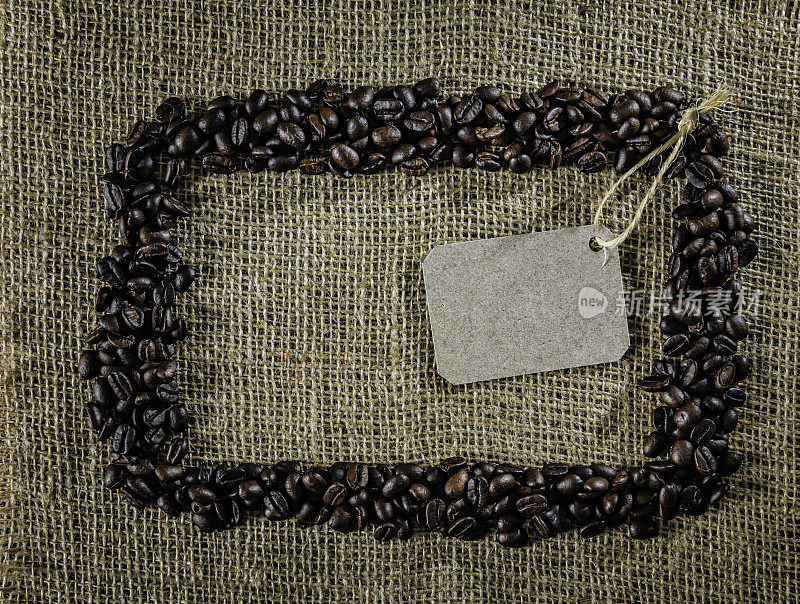 烤生咖啡豆制作框架在黄麻背景与复制空间和空白标签