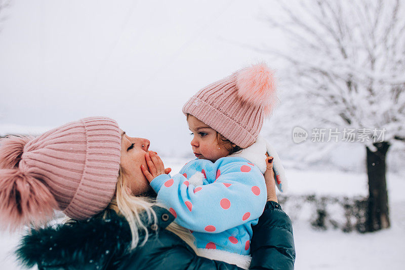 快乐的妈妈喜欢和她的孩子在雪地里玩