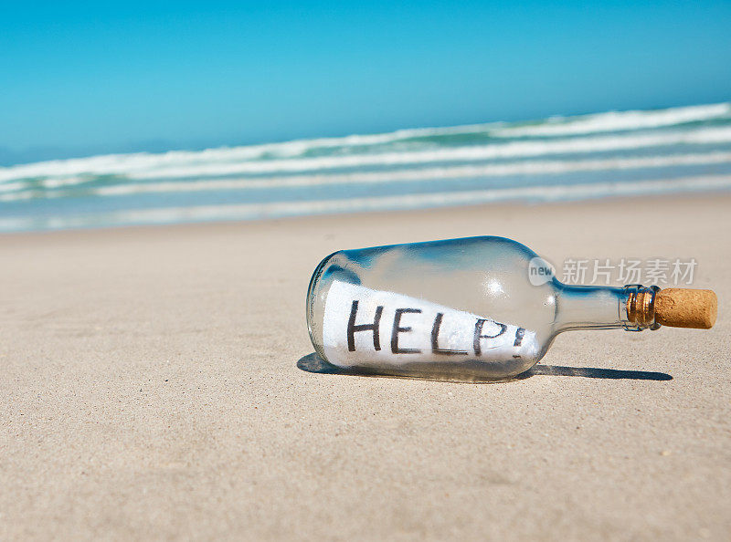 在荒芜的海滩上，洗过的瓶子里装着一张纸条，上面写着“救命!”