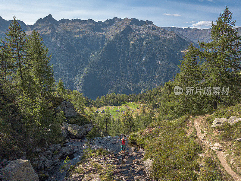 无人机鸟瞰图-夏天，年轻女子在河边徒步旅行，手臂张开庆祝个人进球