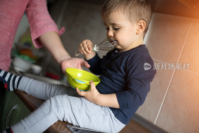 孩子在吃搅拌器里的奶油