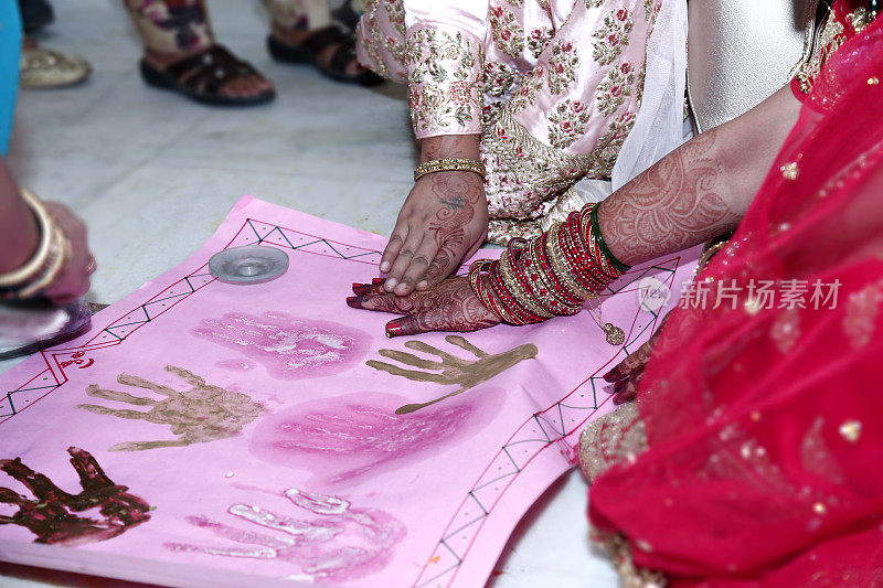 婚礼后的曼海蒂仪式，新郎和新娘的手印在图表纸上