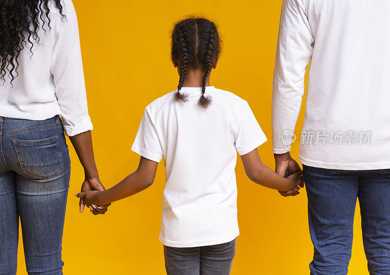 黑人小女孩牵着养父母的手，后视镜