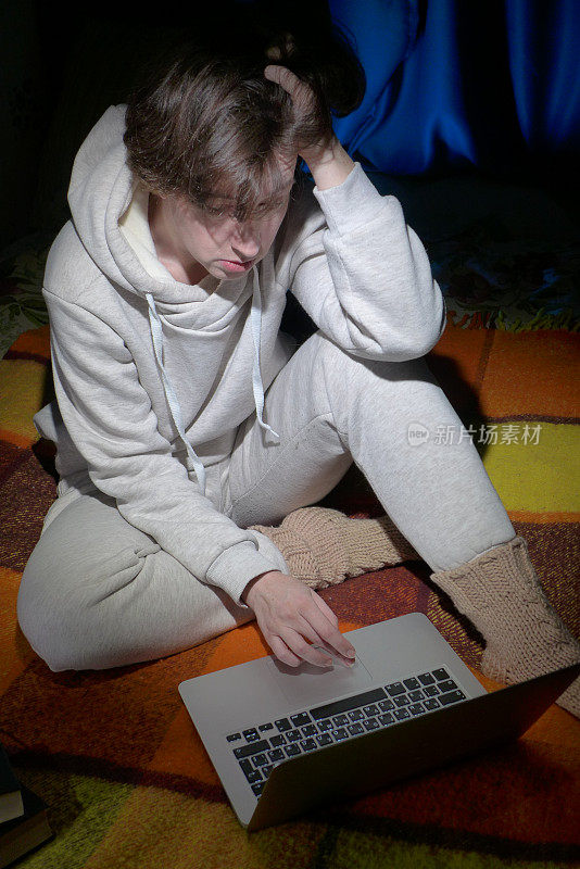 女人正坐在沙发上使用笔记本电脑