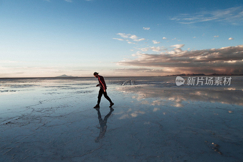 夕阳下，乌尤尼盐沼里，一个人走在路上