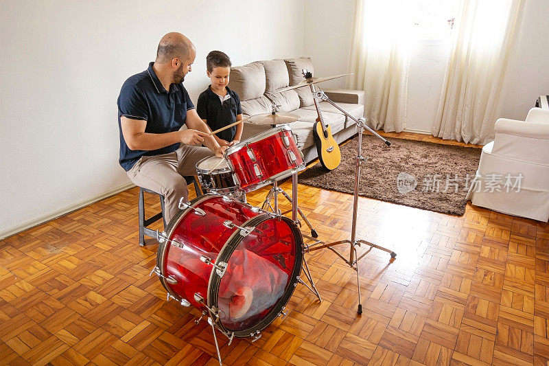父亲和儿子在家里演奏音乐。