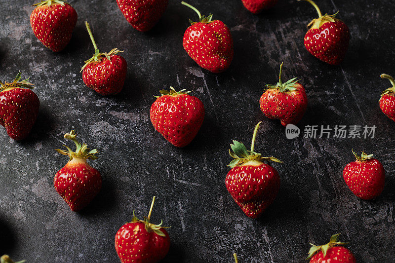 头顶上是一排排不完美的自家种植的草莓，映衬着深色大理石的背景。