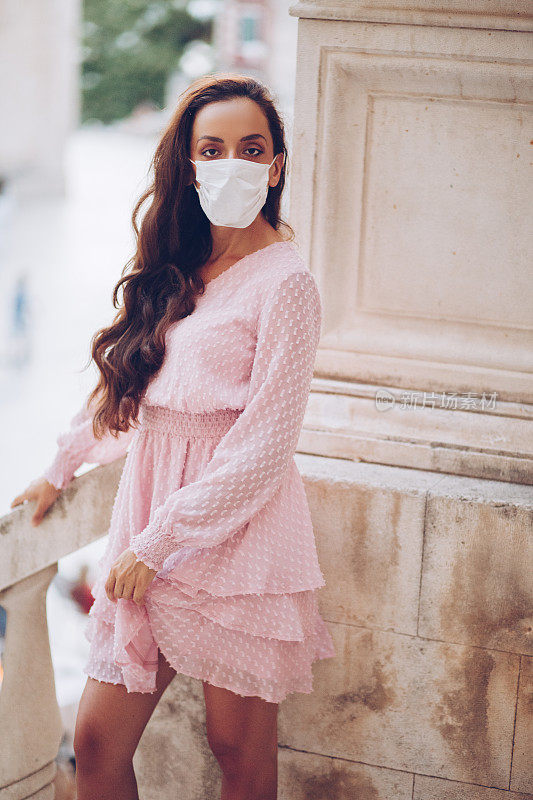 时尚女性戴着防护面具在城市中摆姿势