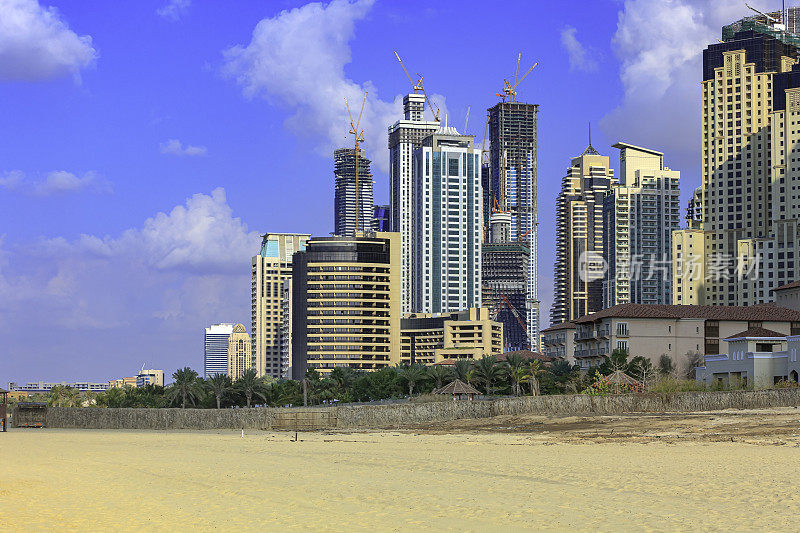 阿拉伯联合酋长国迪拜-乌姆苏凯姆海滩，摩天大楼和建筑映衬着罕见的蓝天和午后的阳光。复制空间;没有人。