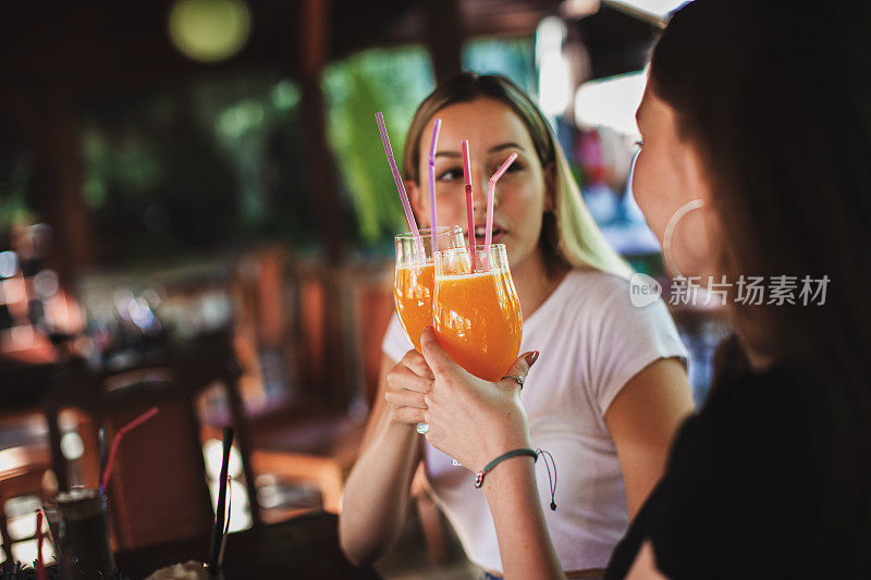 美丽的女人享受在咖啡和果汁在咖啡店