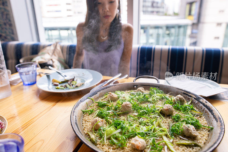 年轻女子看着桌上的海鲜饭