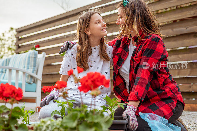 成年妇女和年轻女孩在阳台上种花