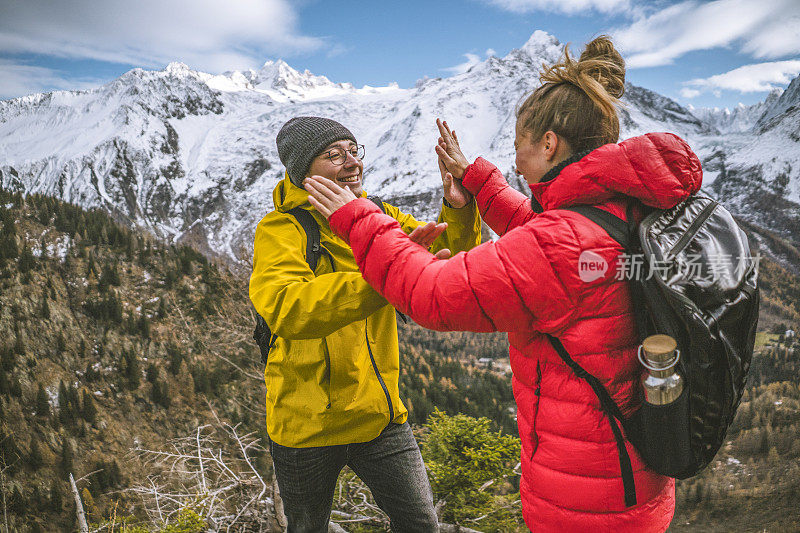 一对年轻夫妇在山脊顶上庆祝