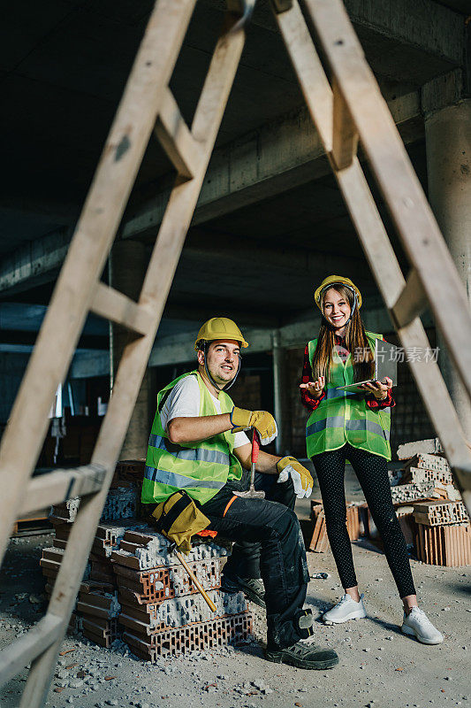 建筑师和建筑工人在建筑工地使用平板电脑