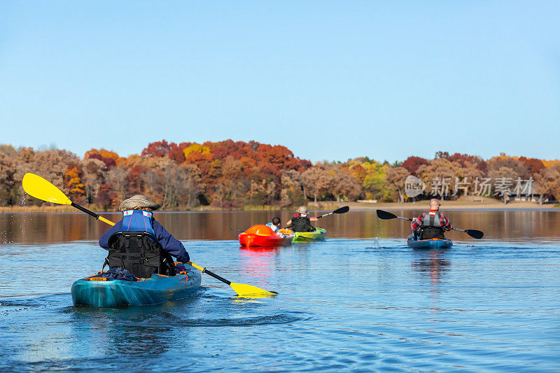 一家人秋天在湖上划皮划艇
