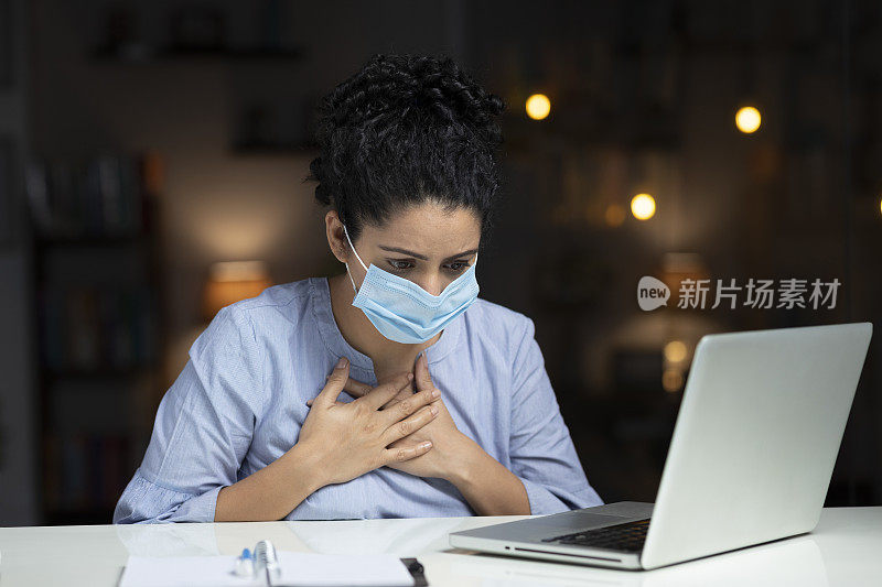 受冠状病毒感染的妇女戴着防护口罩，表现出胸痛、呼吸问题和不适症状:-图片