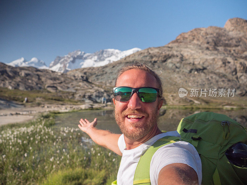 一名男子在徒步旅行时自拍，背景是冰川