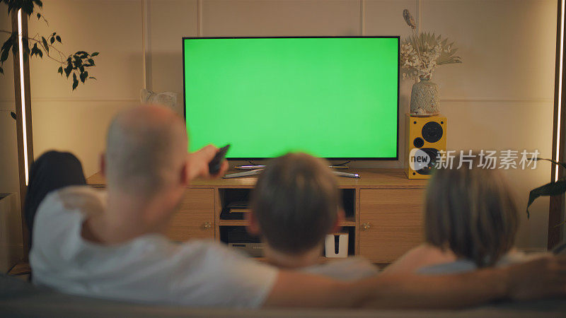 流行病期间的屏幕时间。父亲和儿子在看电视。屏幕上的色度键