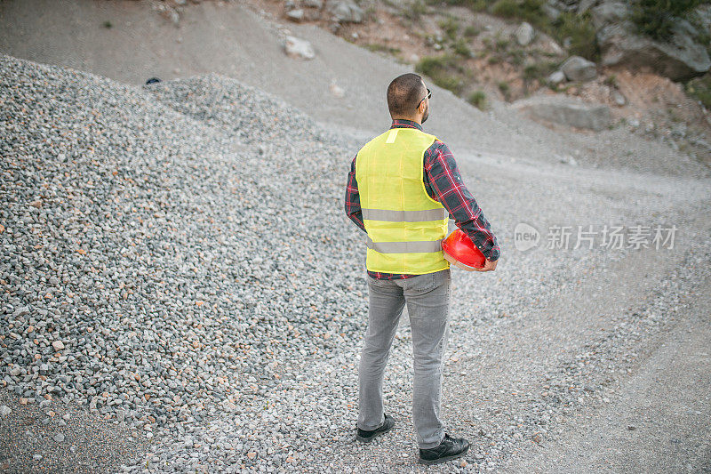 工程师穿着反光服站在采石场欣赏风景