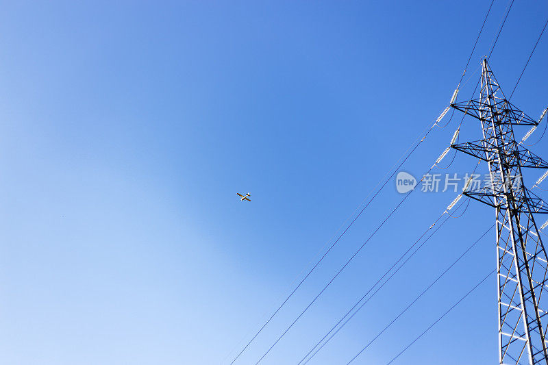 在晴朗的蓝天下拍摄的低角度电塔。飞机飞得越来越高。马德里,西班牙