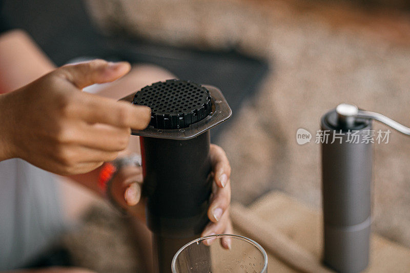 亚洲咖啡师正在使用手工咖啡机aeropress来煮咖啡