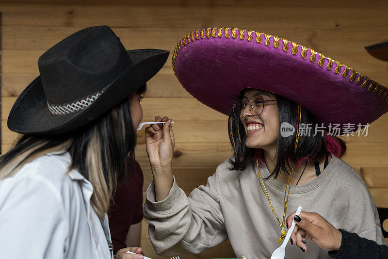 拉丁朋友在一家餐厅的墨西哥酒吧里玩墨西哥帽子玩得很开心