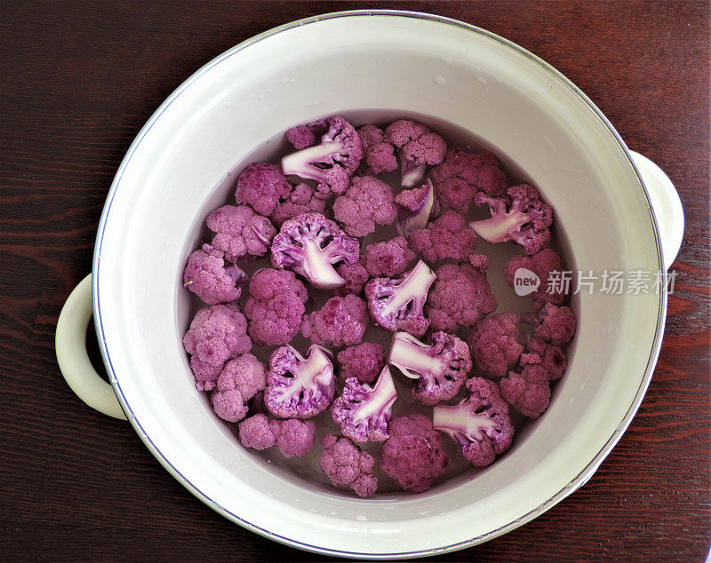 日本。将紫色的花椰菜放入锅中加水。