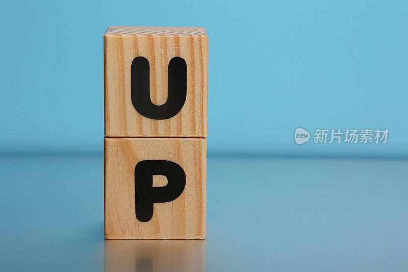 UP字在蓝色背景的木制立方体上