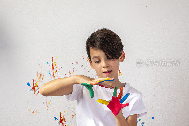男孩在他的手上展示彩色颜料
