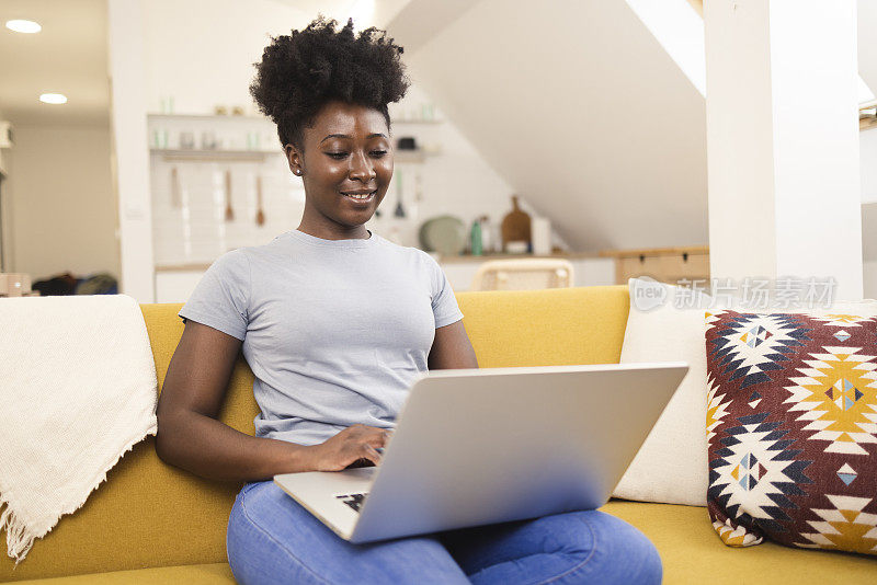一位非裔美国女企业家在她的客厅里做自由职业者